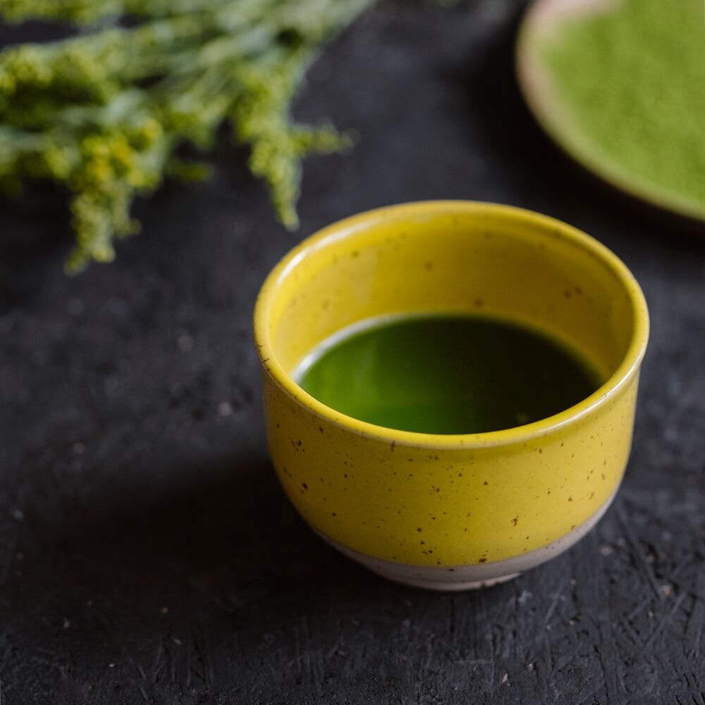 Matcha drink in a yellow matchawan