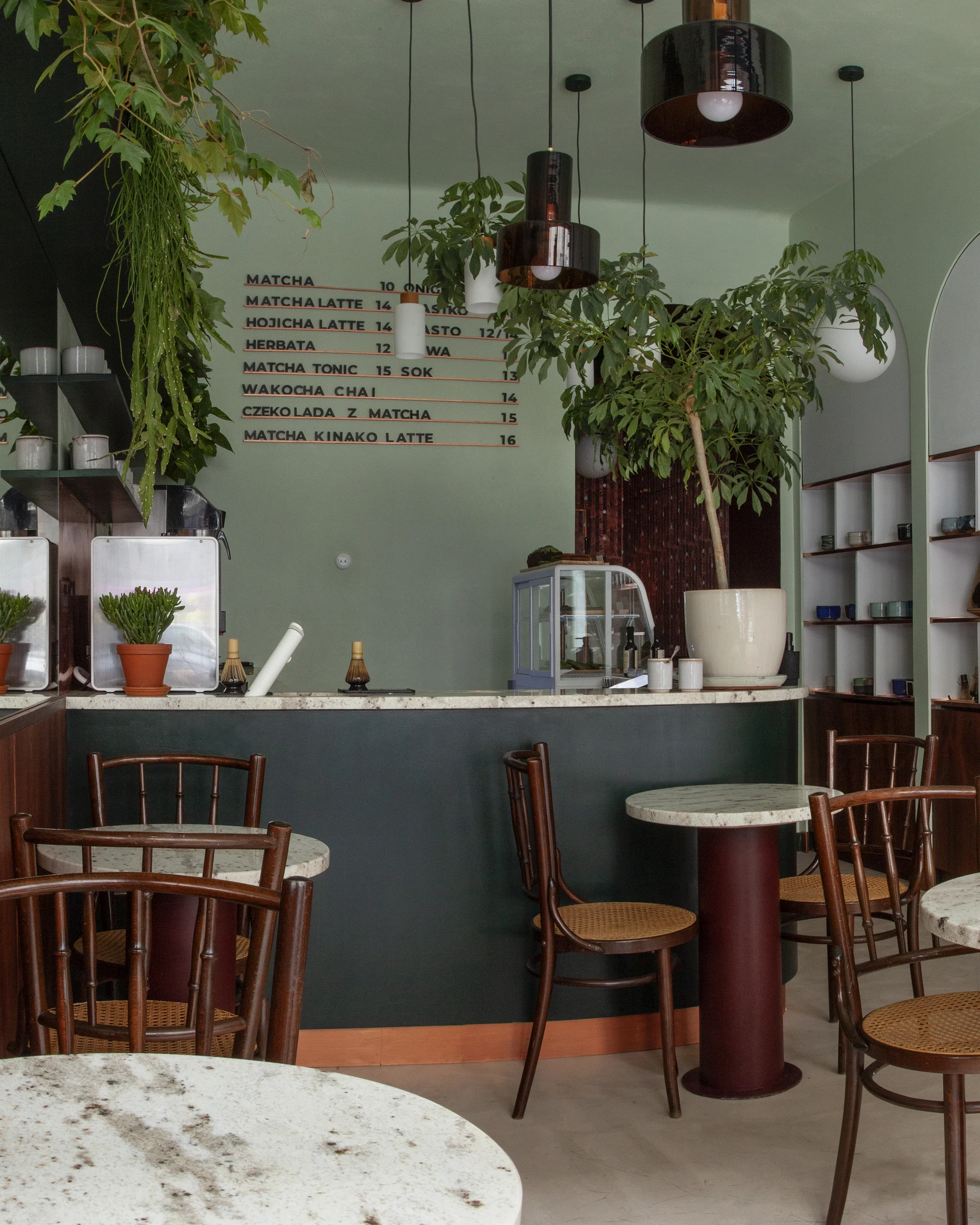 tearoom with green walls, marble tables, green walls and plants